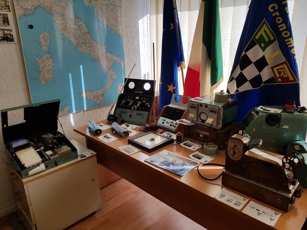 Sala espositiva con mappa d'Italia, bandiere e strumenti storici del cronometraggio.